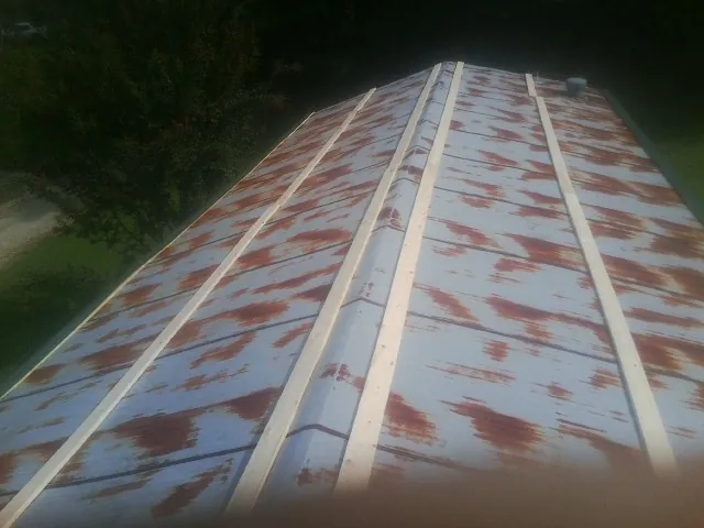 Rusted metal roof panels with new wood purlins before replacement — Storm Damage Roof Repair in New Milford by Roofing Brothers