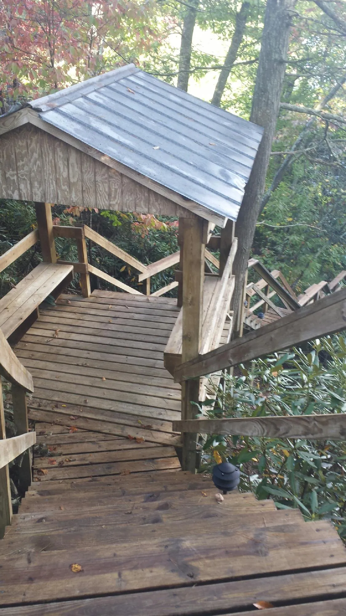 Metal roofed shelter over wooden steps on a wooded walkway — Skylight Repair & Installation work by our crew in New Milford